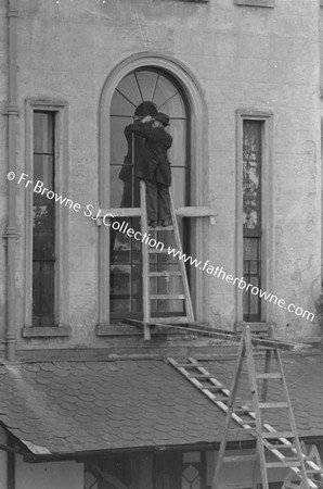 MAN FITTING LEADE GLASS AT RERE OF 35 LEESON STREET